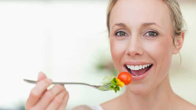 Person with a bright smile eating healthy food
